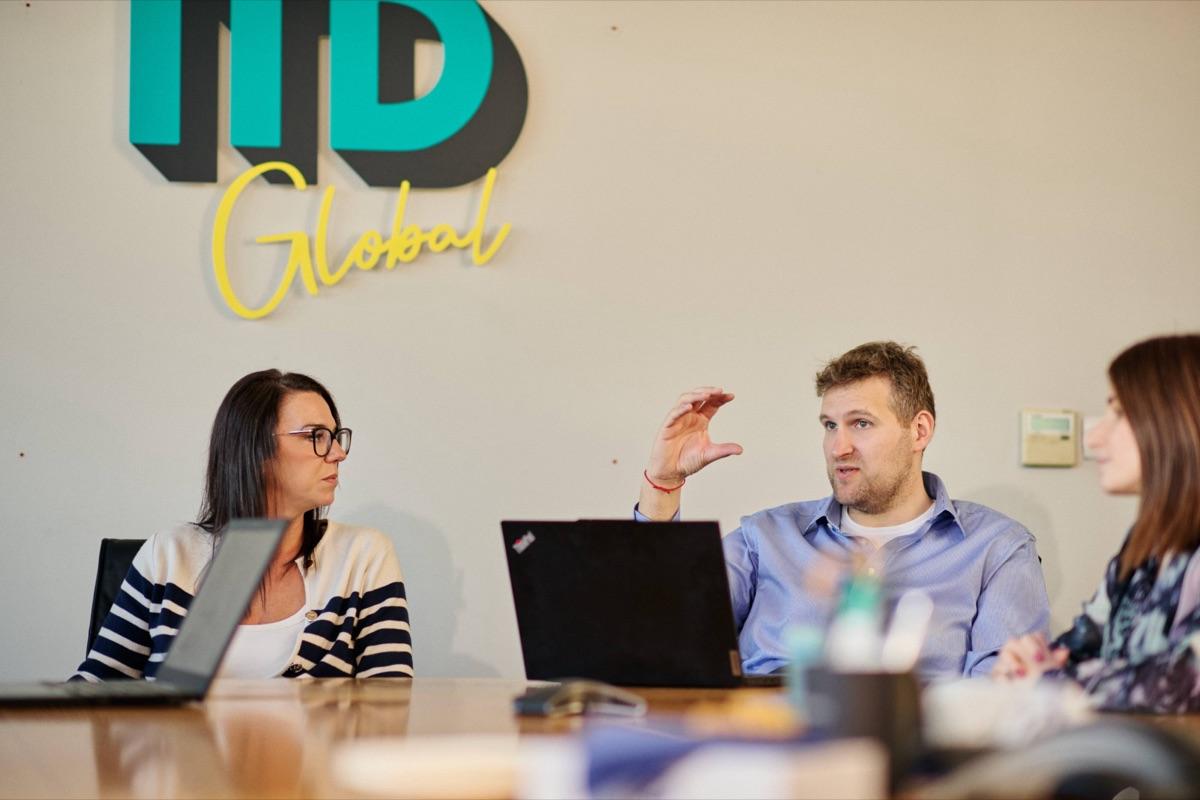 ITD Global team members in discussion under the company logo