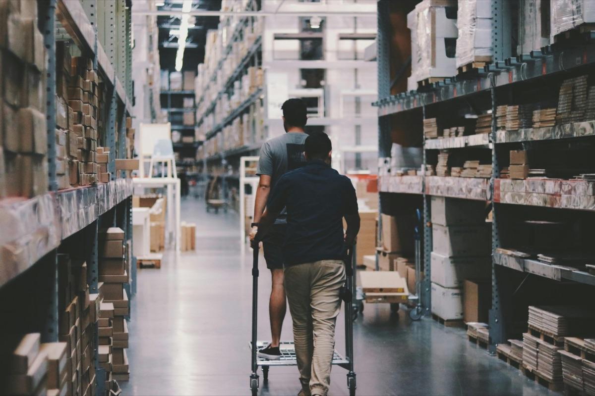 Two operators walking a warehouse aisle with a trolley — 3PL fulfilment