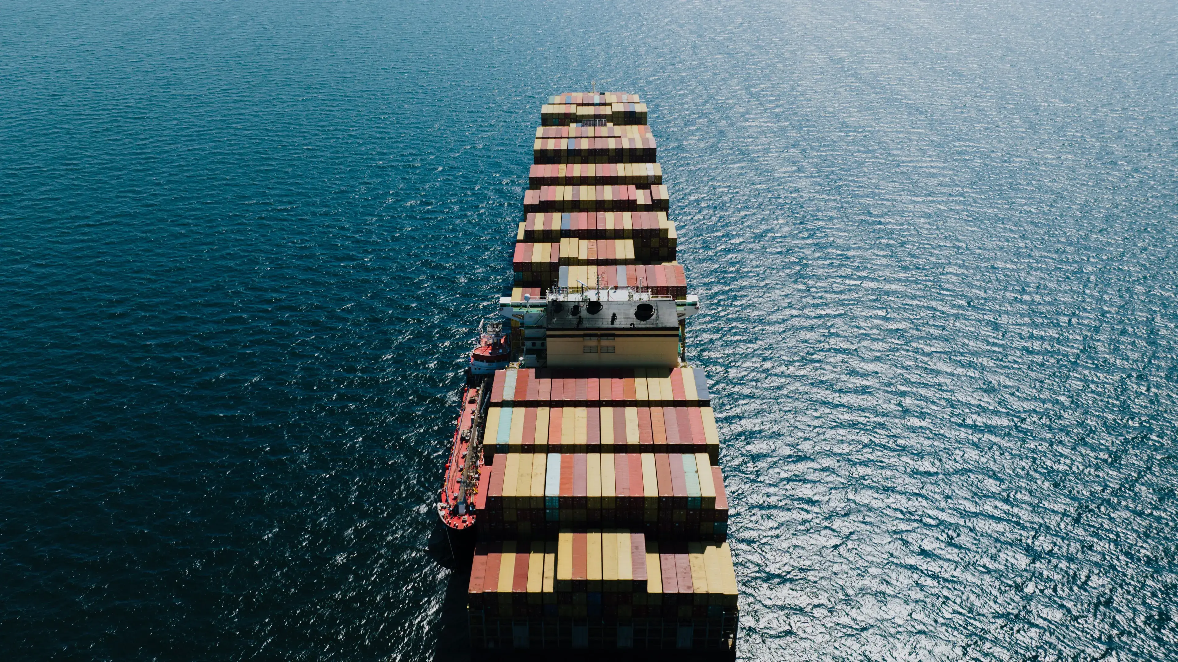 Container ship laden with freight containers at sea, seen from above