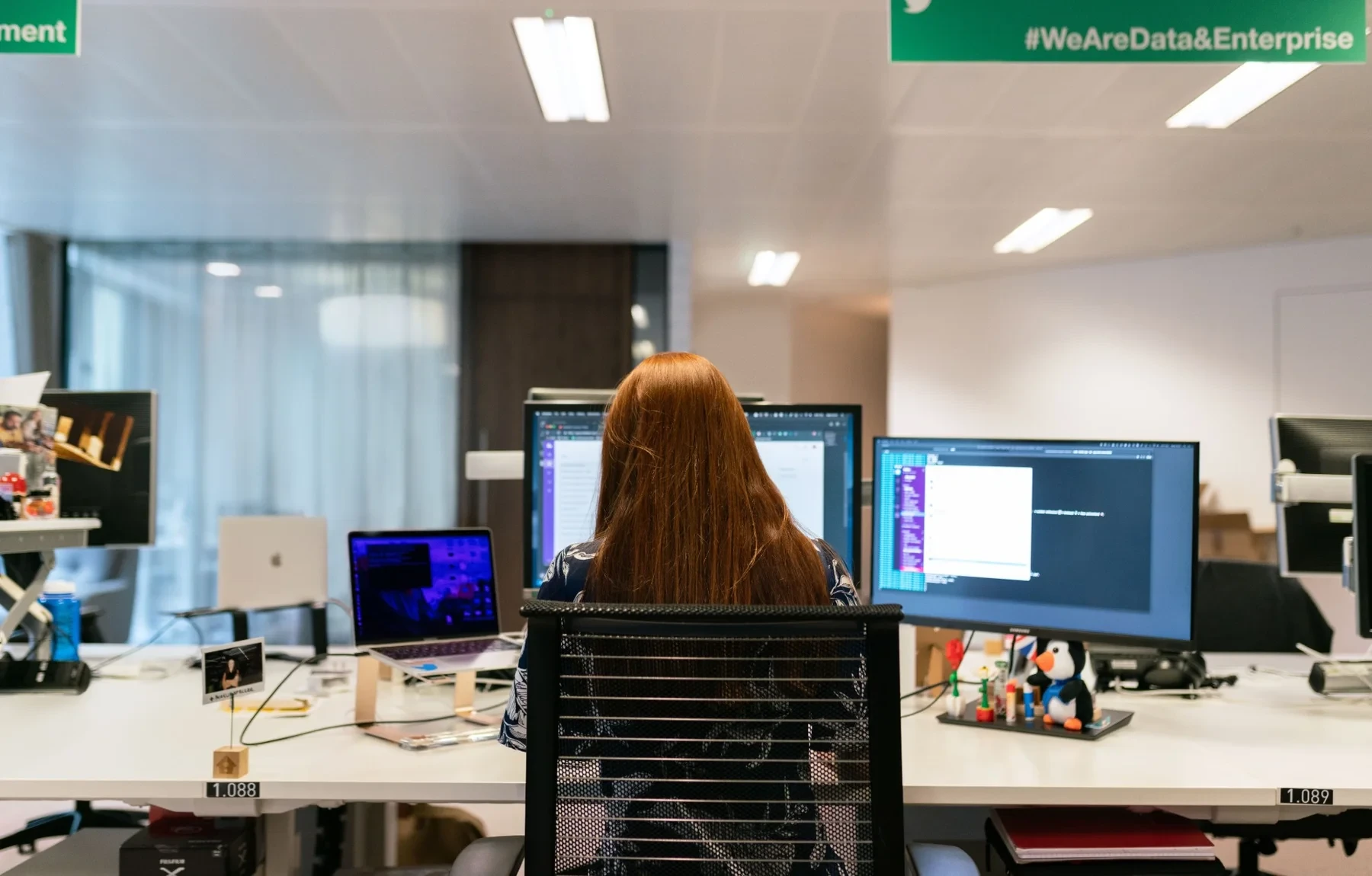 Operations analyst at a multi-screen workstation in an enterprise logistics office